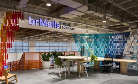 Escritório da brMalls com letreiro da marca e mesas de trabalho